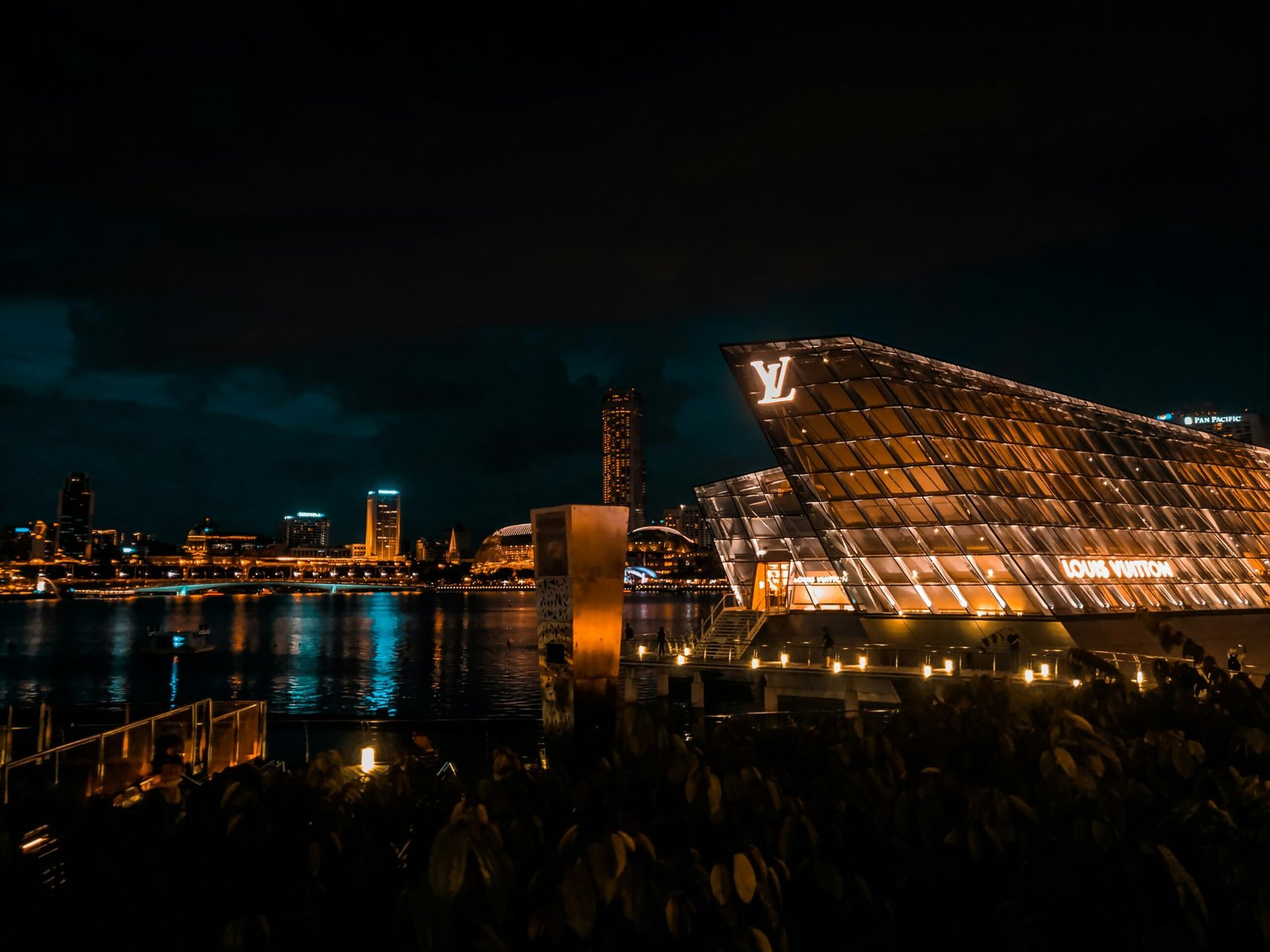 people standing near glass building during night time